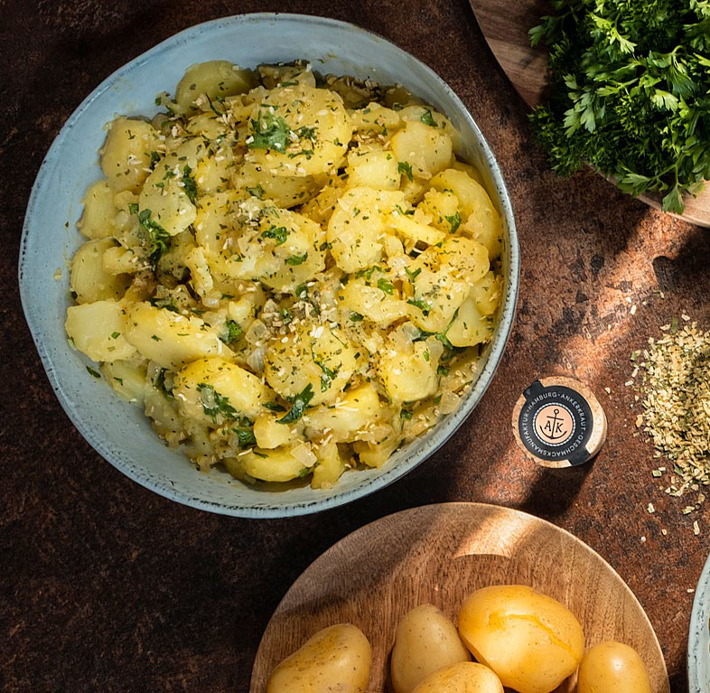 Lecker dekorierter Kartoffelsalat mit Gewürzglas von Ankerkraut daneben