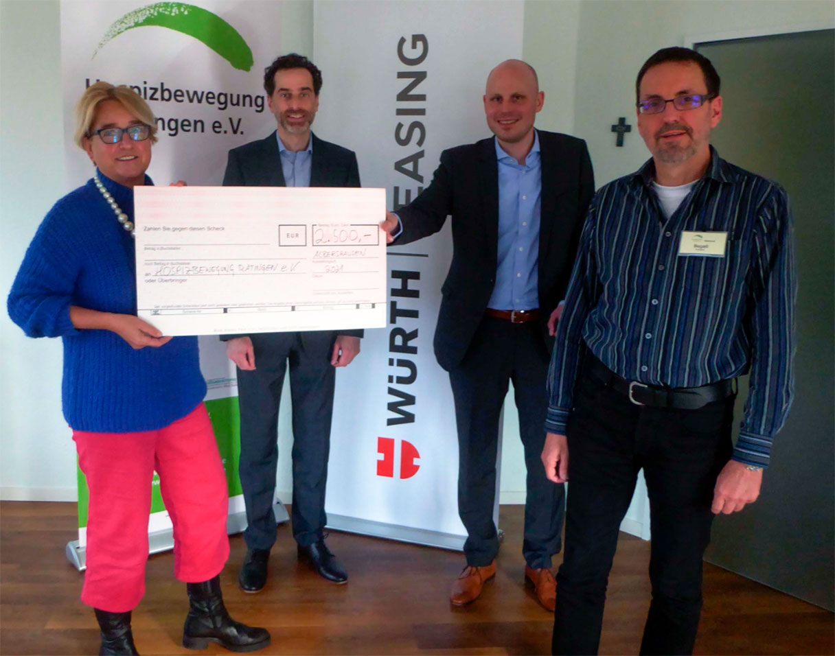 Mann übergibt Spenden Scheck an eine Frau