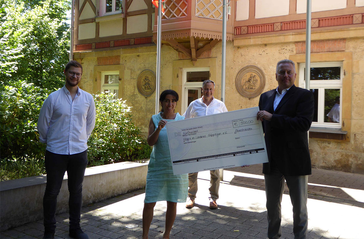 Mann übergibt Spenden Scheck an eine Frau