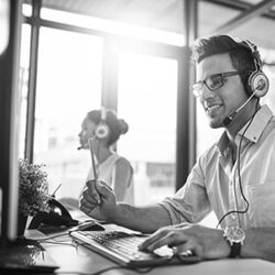 Junger Mann mit Headset am Computer